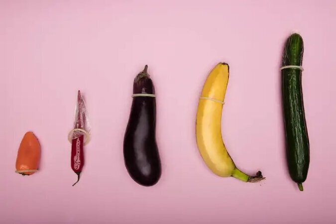 An eggplant, banana, and pepper laid side-by-side